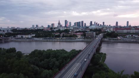 cinematic drone footage of warsaw skyline with vistula river and bridge filled with traffic left parallax with clouds