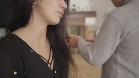 close-up of middle eastern boy combing the smiling woman with long dark hair and hazel eyes