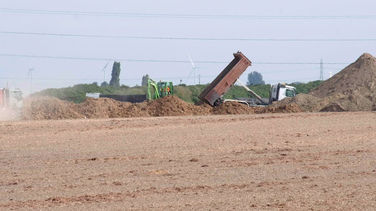 Trucks carrying soil during a road construction