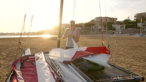 man preparing catamaran on the beach in the morning