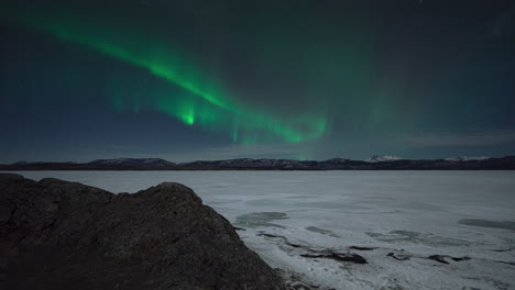 aurora borealis over frozen lake laberge in yukon, canada.timelapse