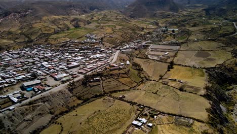 aerial view towards small town in the altiplano, sunny evening, putre, chile - reveal, drone shot