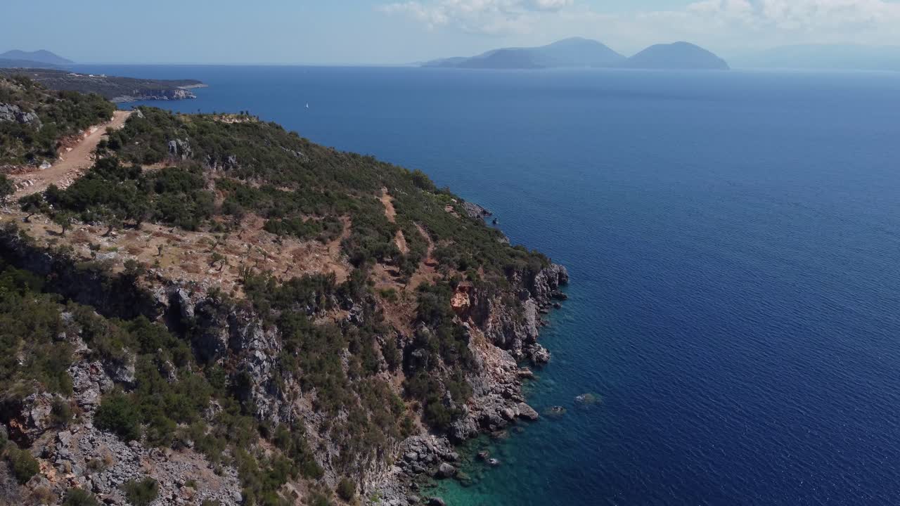 Aerial: Hill island with blue sea in Agiofili, Lefkada, Greece - drone flying tilt down shot
