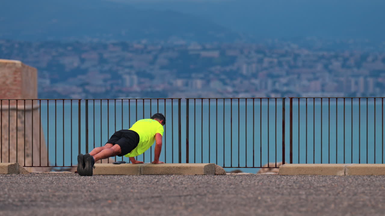 Man working out near the sea in Antibes, France with the city and the mountains on the background