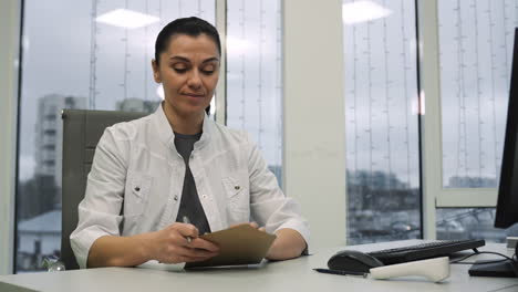 mujer poniendo papel dentro de un sobre