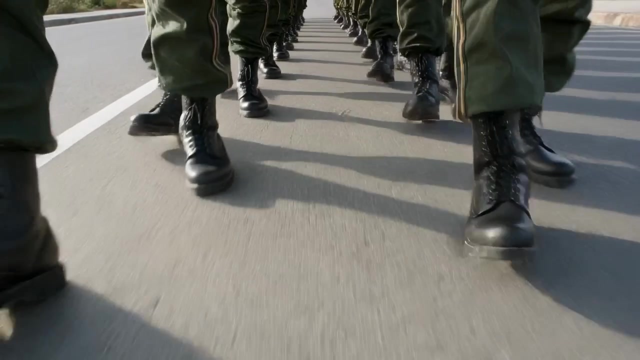 Command sounding, marching soldiers stepping on road for drill, with olive trousers and boots