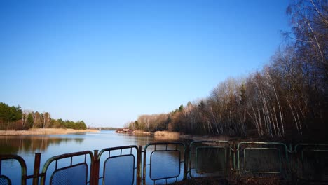 Pripyat-Blue-River-behind-rusted-metal-gate,-Chernobyl