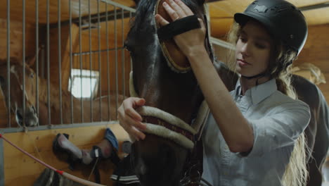mujer arreglando un caballo en un establo