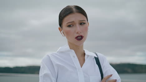 Retrato-Mujer-Auriculares-Inalámbricos-Hablando-Frente-Al-Cielo-Nublado.-Chica-Hablando-Por-Teléfono