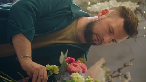 male florist collects bouquet for customer vertical shot