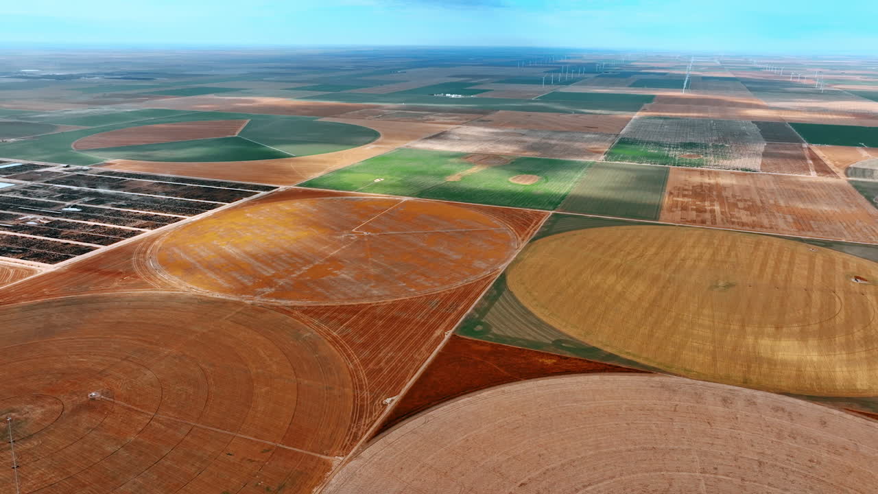 Vast fields divided into the parts with circle areas prepared for farms. Agricultural plantations with center-pivot-irrigation. Top view.