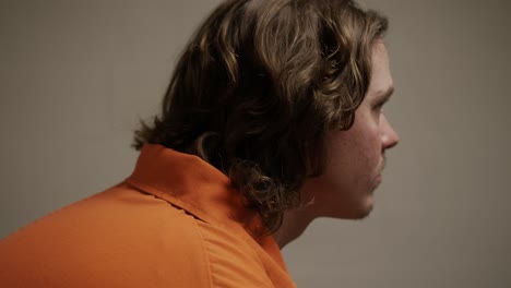 sad, solemn man, inmate, prisoner, sits in his prison cell