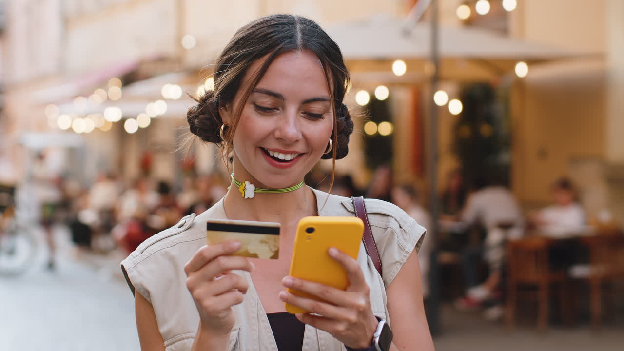 Young woman using credit bank card smartphone while transferring money purchases online shopping