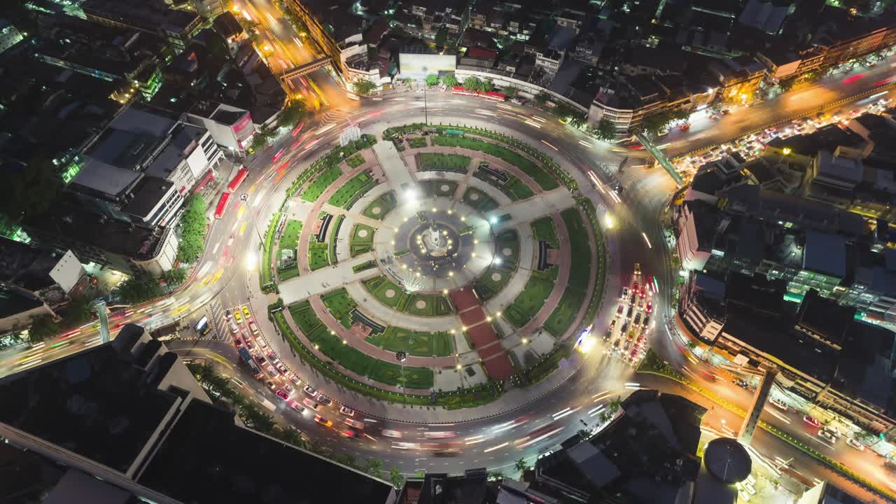 Time-lapse or Hyper-lapse Zoom in Aerial view 4 way road roundabout circle or intersection traffic at night for transportation concept.