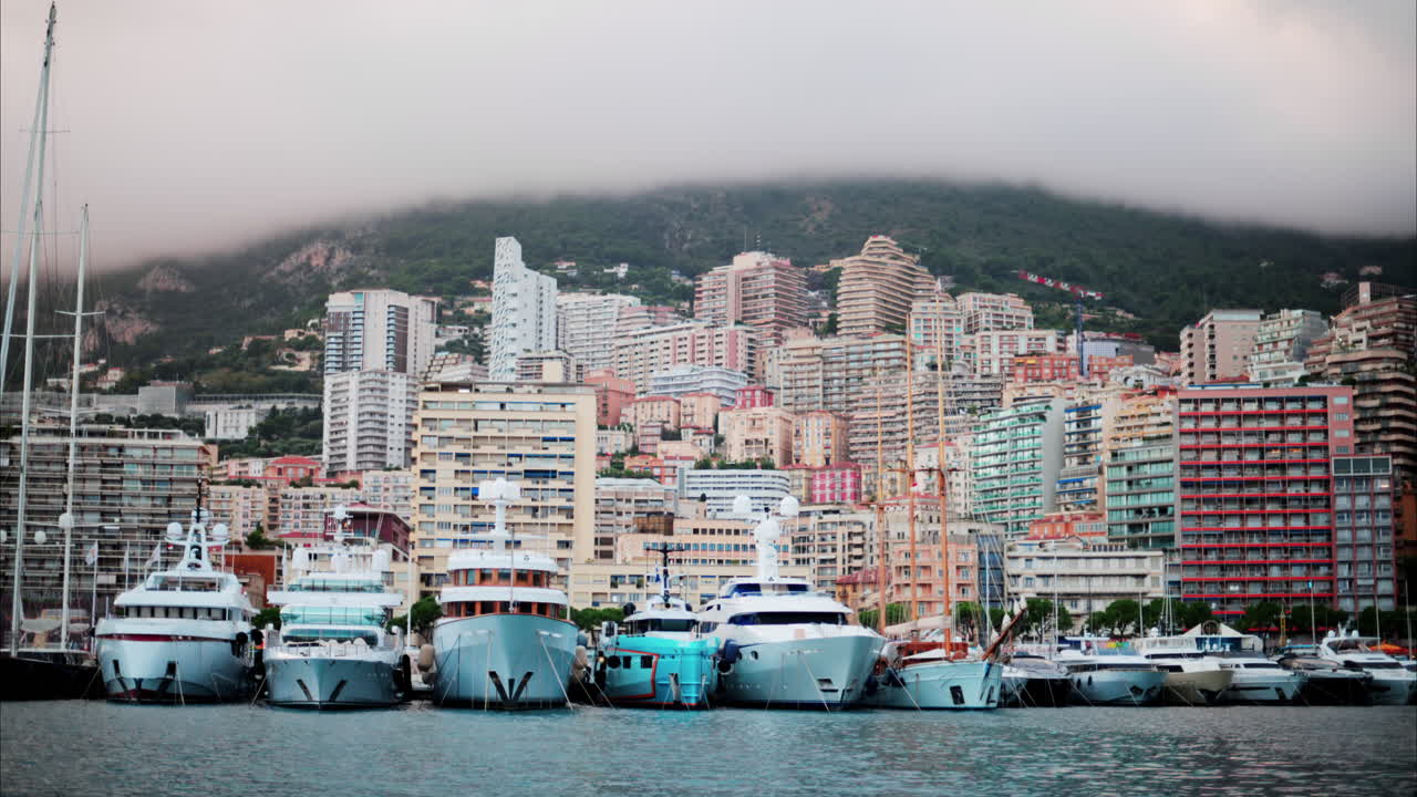 View of boats docked in the Monaco Marina with the skyline of the city on the background