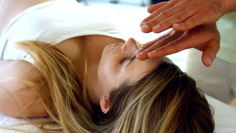 therapist performing reiki on patient