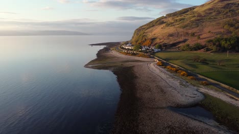 Aerial-view-of-the-Scottish-town-of-Catacol-on-the-Isle-of-Arran-at-sunset,-Scotland