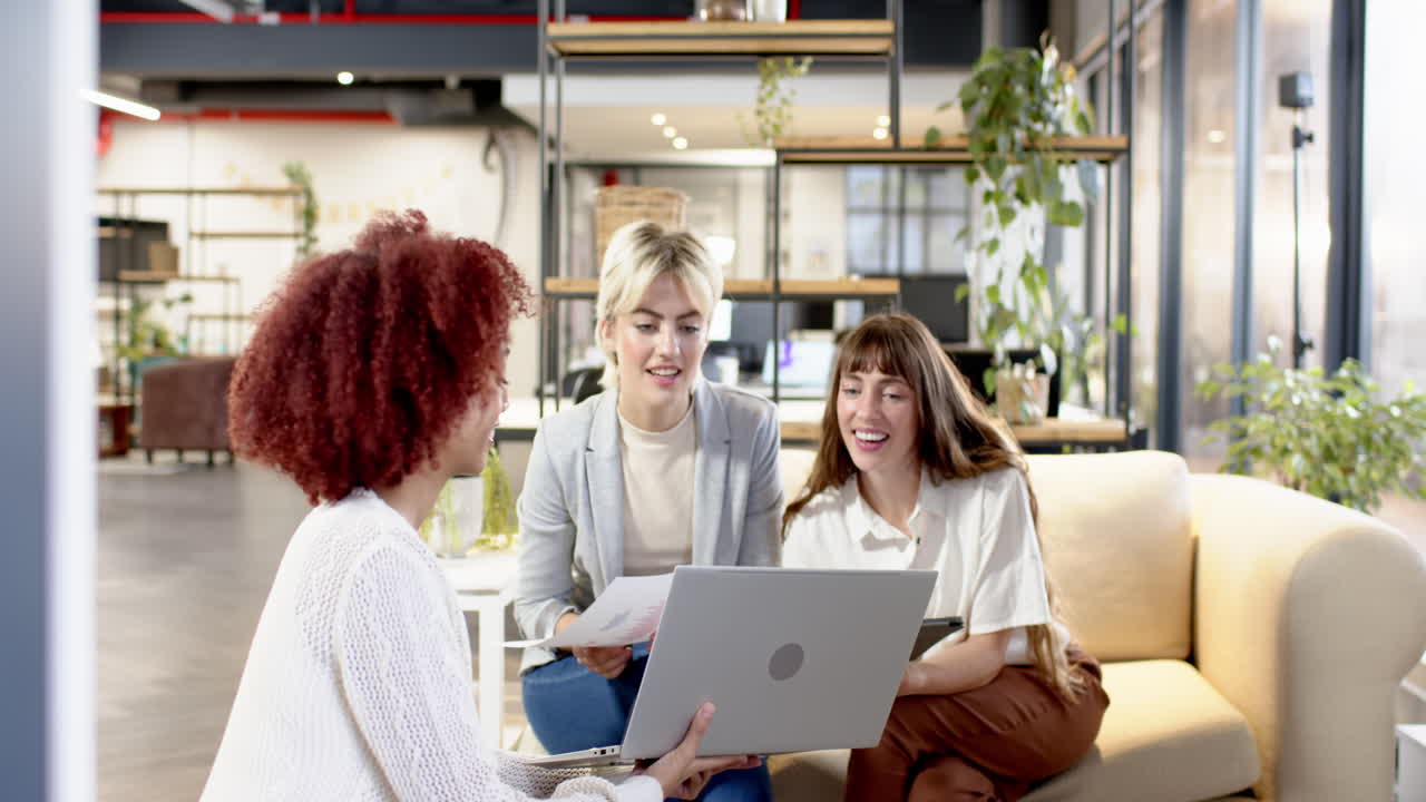 Collaborating in modern office, women discussing creative writing business ideas