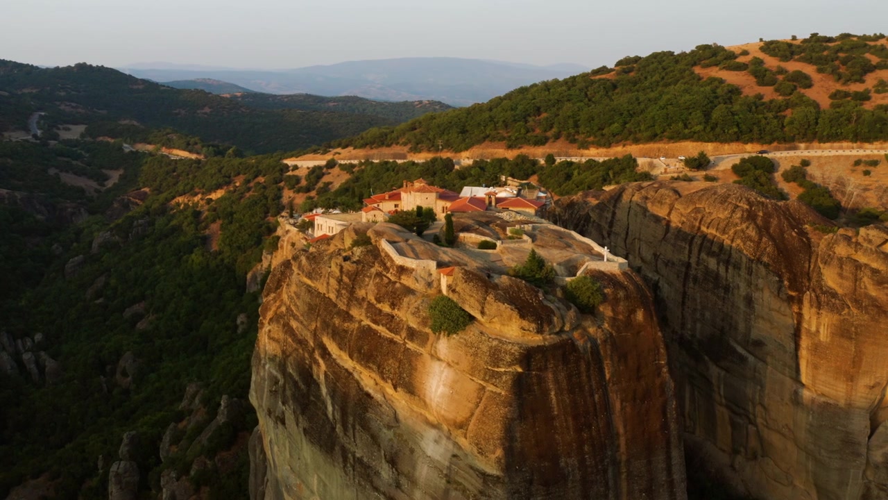 Mosteiro da Santíssima Trindade em Meteora durante o pôr do sol em Kalampaka, Grécia. - Tomada aérea
