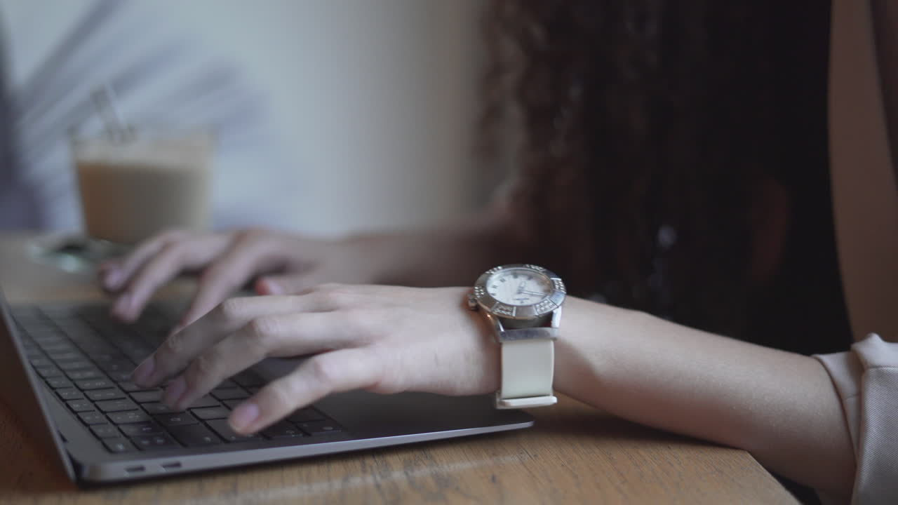 Woman Working on Laptop in a Cafe