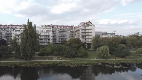 Video-Panorámico-Lateral-De-Drones-Aéreos-De-Edificios-Y-Personas-Al-Lado-Del-Lago-En-Varsovia