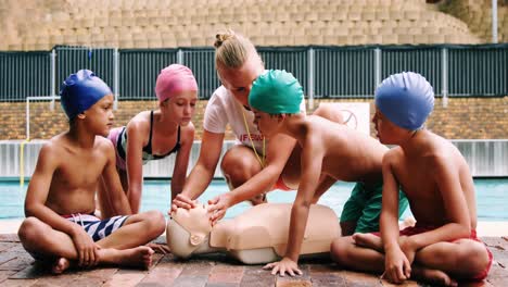 swim coach training students on dummy