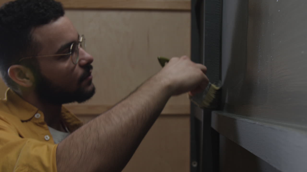 Man painting shelf with paint brush