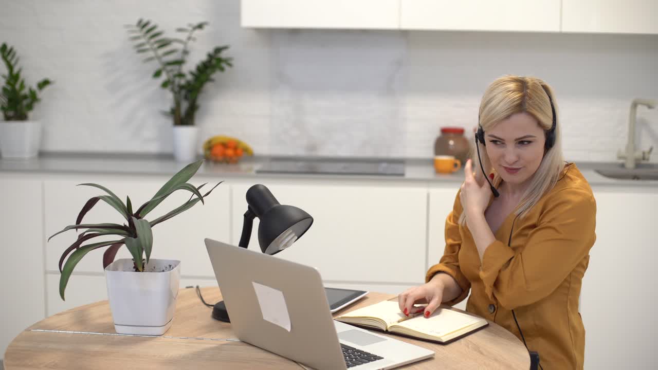 donna che lavora con un laptop in una cucina luminosa. covid-19 coronavirus. distanziamento sociale