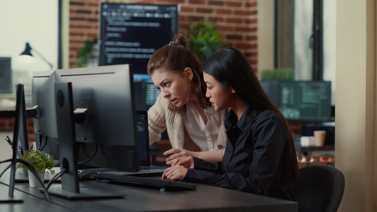 Team of coworkers comparing source codes running on laptop screen and computer monitor
