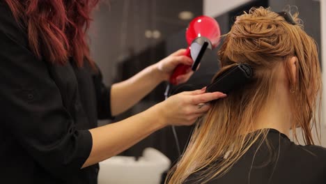 in a contemporary salon environment, a skilled stylist utilizes a blow dryer and straightener on a clients hair