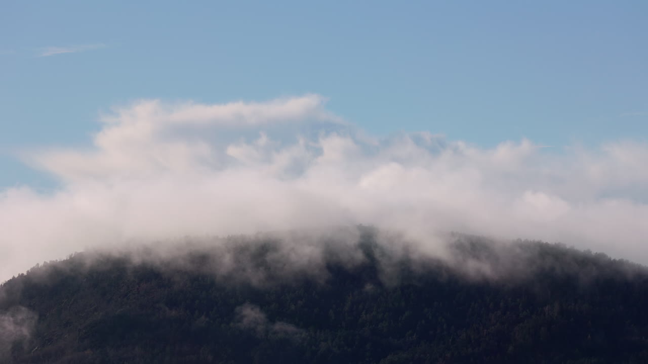 Low clouds across Damsgårdsfjellet, creating layered silhouettes and hiding the summit