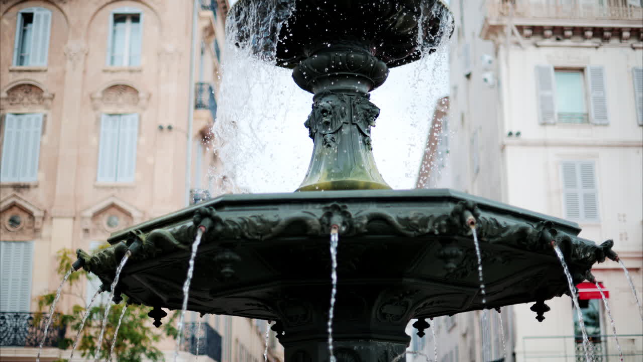 Close up of a water pouring in a fountain with a blurry background in Cannes, France