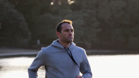 slow motion shot of caucasian man running on the beach in auckland, new zealand