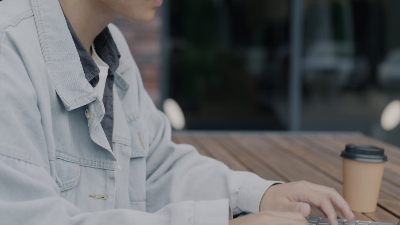 Person Working on Laptop in Outdoor Cafe