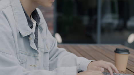 person working on laptop in outdoor cafe