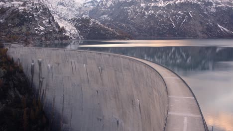 Massive-dam-in-a-mountain-lake-at-sunset