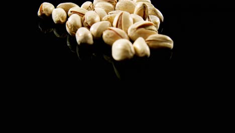 pistachos cayendo sobre un fondo negro 4k
