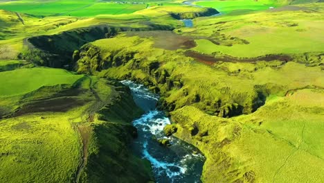 4k drone, aerial cinematic, unique and dramatic shots of a beautiful green landscape in iceland with blueish water in the river freely flowing in between