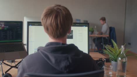 los compañeros de equipo trabajan en la oficina en diferentes estaciones de trabajo