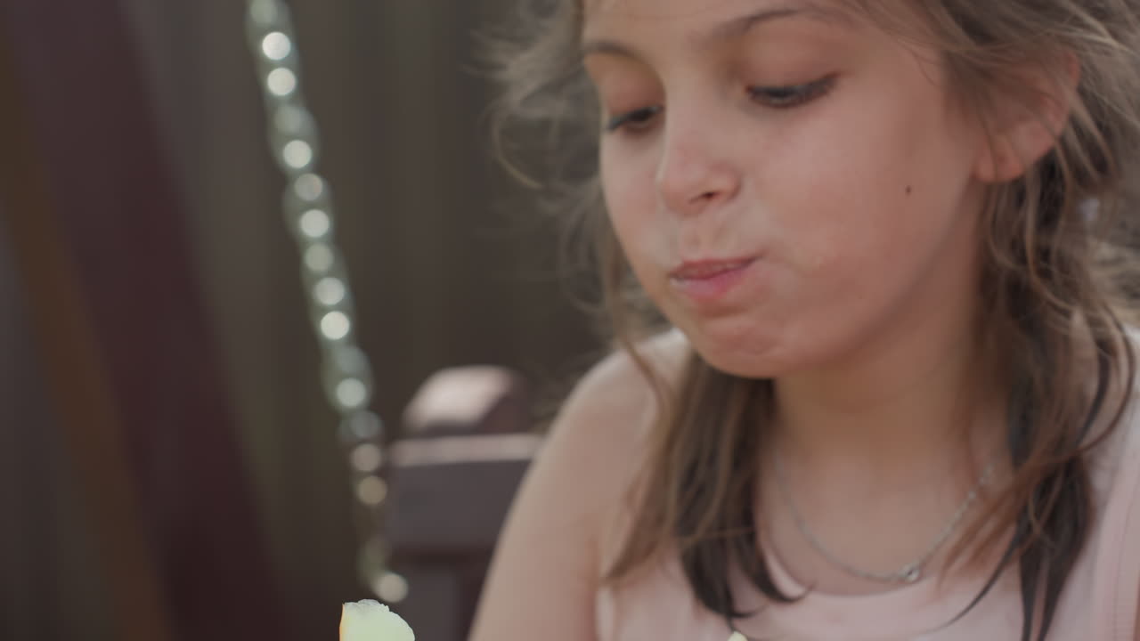 Close View Of Girl Savoring Summer Fruits Outdoors, Child Happily Peeling And Tasting Ripe Melon Outside On Porch, Girl Indulging In Juicy Melon Outdoors While Child Peel And Taste Ripe Summer Fruit
