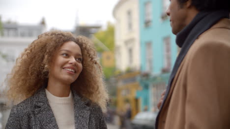 una elegante pareja de jóvenes hablando en la calle de la ciudad