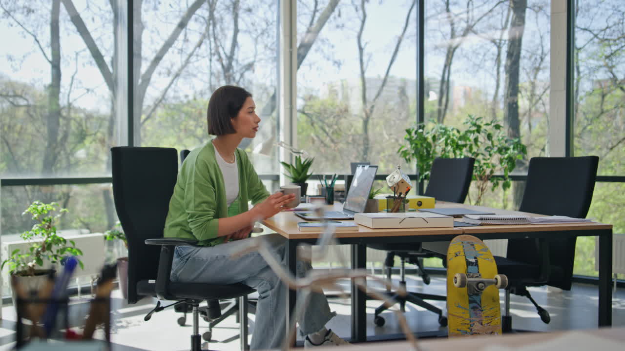 mujer de negocios tomando un descanso para el café sentada en el escritorio de la oficina. mujer creadora relajándose