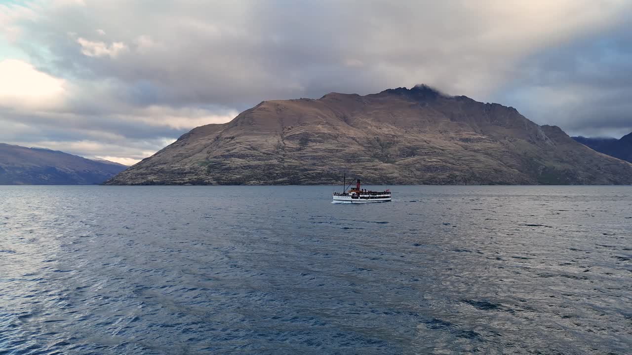 A seaplane glides over Lake Wakatipu with mountainous backdrop under dramatic skies. Captured in Queenstown, New Zealand