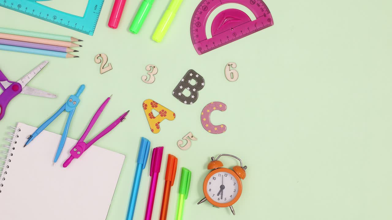 Okul yazı kırtasiye malzemeleri açık yeşil arka plan üzerinde hareket ediyor. Stop motion.