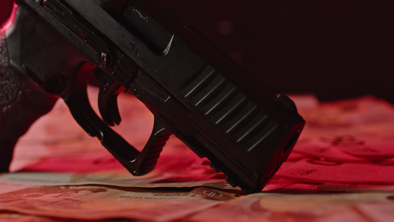 un cañón de arma apoyado en una pila de dinero con sirenas parpadeantes en el fondo