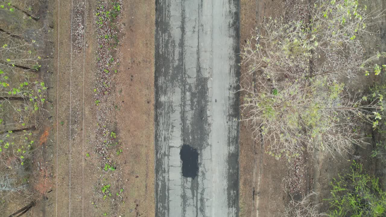 Top-down View of a Cracked Paved Road in a Rural Area