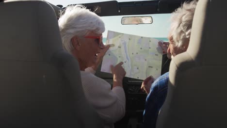 senior couple looking at a map in a car