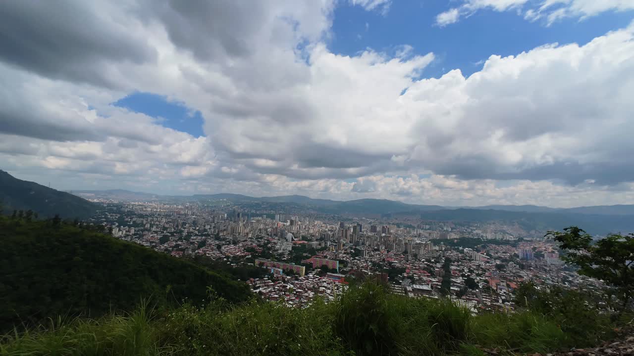Wide aerial view of Caracas skyline seen from El Ávila mountain under dramatic clouds and natural light