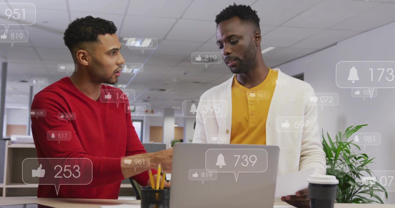 Coworkers pointing and tapping laptop, initiating floating alert icons updating marketing metrics