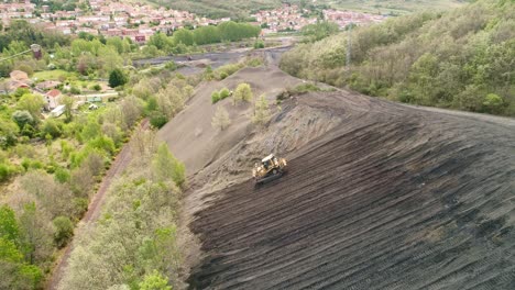 bulldozer working on a steep slope, aerial view